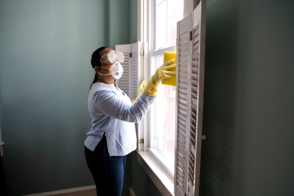 Mastering the First Impression: Your intriguing post title goes here When renovating a home, you should use a damp sponge or cloth to clean dust collected on a window sill, as the dust may contain asbestos or lead-based paint. Home maintenance is an ongoing process for any homeowner, and here we see an African- American woman who’d taken a damp sponge to her window’s frame, in order to remove accumulated dust particulates. Note how the homeowner had donned a pair of waterproof gloves, a facemask, and a pair of goggles, prior to beginning this task.